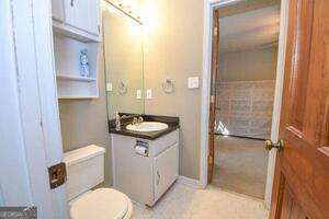 bathroom featuring tile patterned flooring, vanity, and toilet