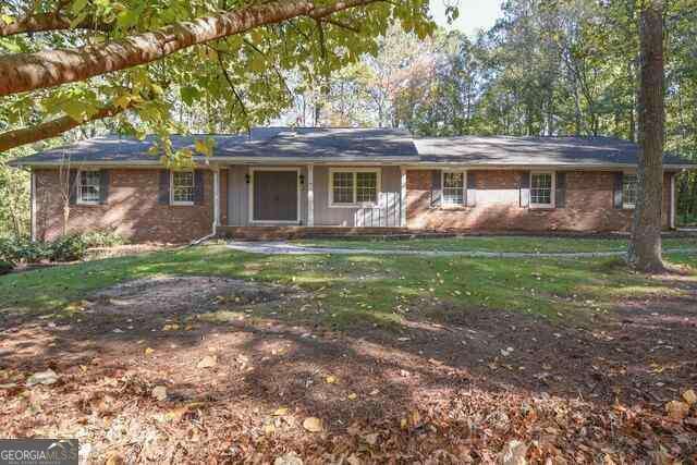 single story home featuring a front lawn