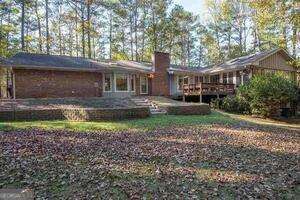 back of property with a deck and a chimney