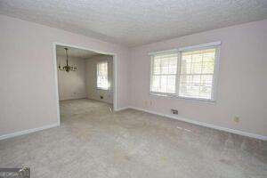 empty room featuring carpet, a healthy amount of sunlight, and baseboards