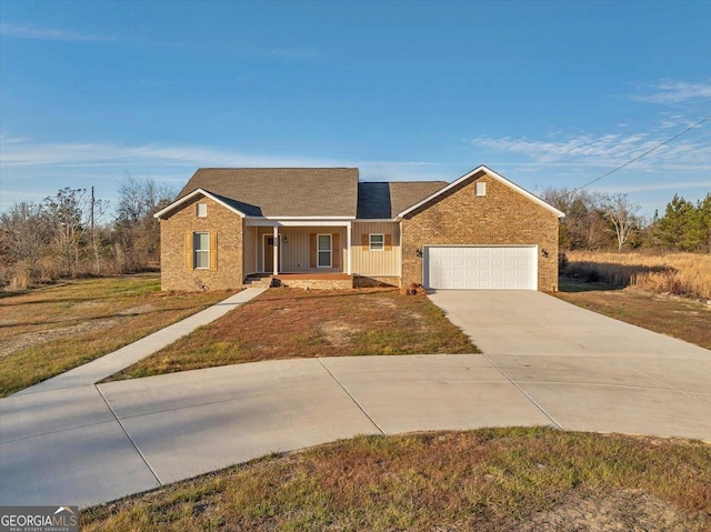 ranch-style house featuring concrete driveway, covered porch, board and batten siding, a front yard, and a garage