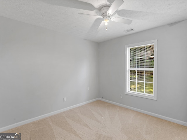 spare room featuring carpet, visible vents, and baseboards