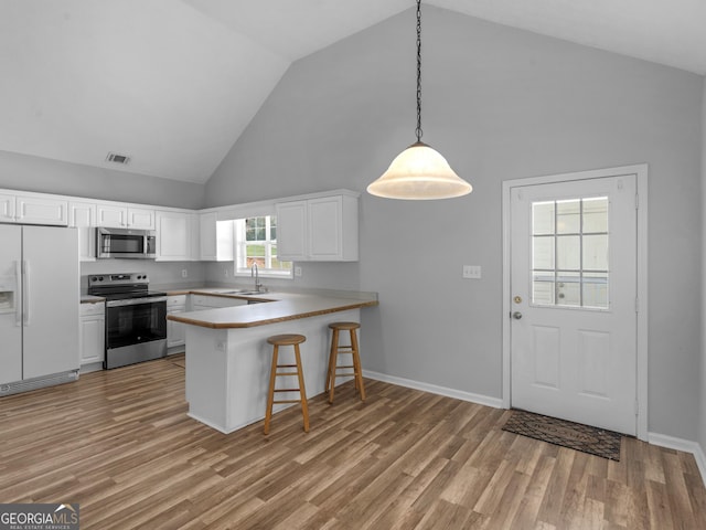 kitchen with a peninsula, light wood-type flooring, visible vents, and stainless steel appliances