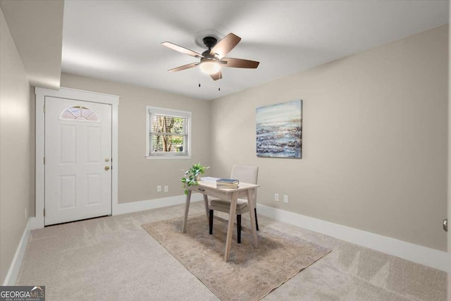 office area featuring a ceiling fan, light carpet, and baseboards