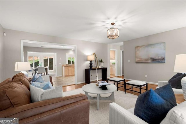 living room featuring baseboards and an inviting chandelier