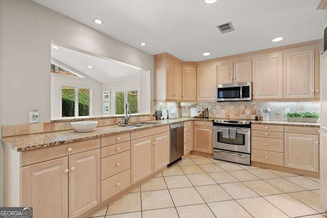 kitchen featuring tasteful backsplash, visible vents, stainless steel appliances, light brown cabinets, and a sink