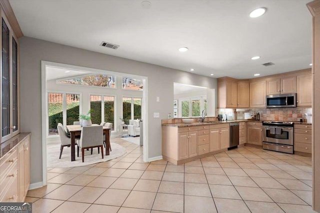 kitchen with tasteful backsplash, visible vents, appliances with stainless steel finishes, light brown cabinets, and a sink