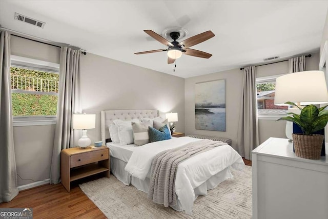 bedroom featuring ceiling fan, wood finished floors, and visible vents