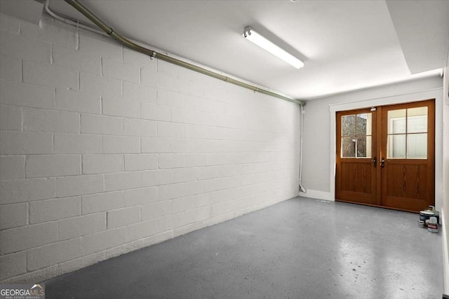 garage featuring french doors and concrete block wall