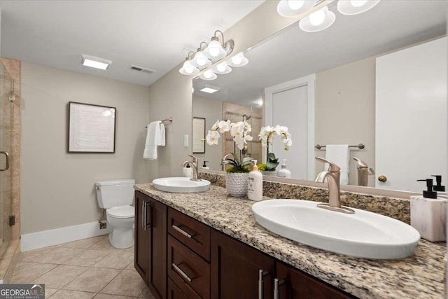 bathroom featuring tile patterned flooring, a sink, a shower stall, and toilet