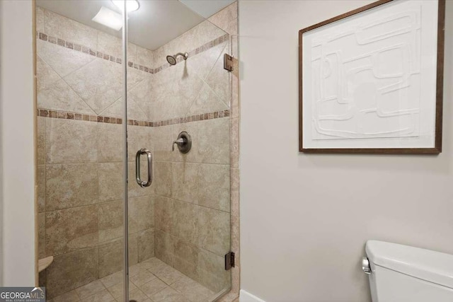 bathroom with a stall shower and toilet