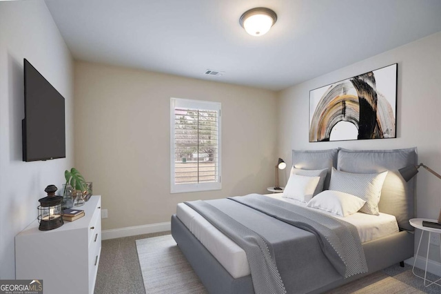 carpeted bedroom with visible vents and baseboards