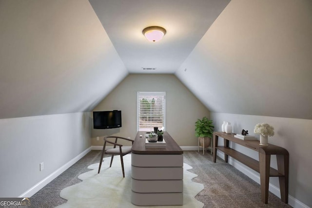 carpeted home office featuring baseboards, visible vents, and vaulted ceiling