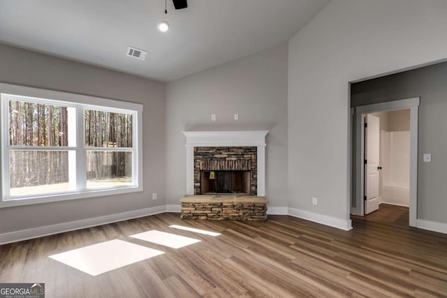 unfurnished living room featuring a fireplace, wood finished floors, visible vents, and baseboards