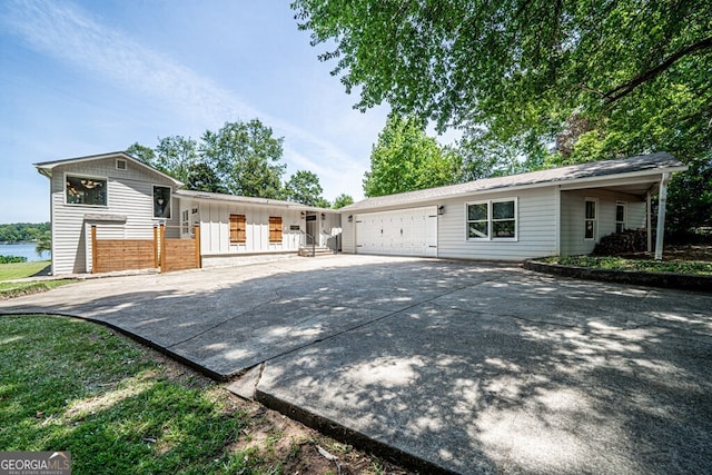 ranch-style house with an attached garage, board and batten siding, and driveway