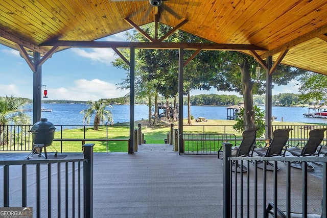 deck with a water view and a lawn