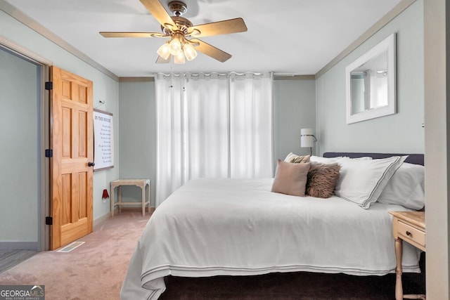 bedroom featuring crown molding, baseboards, multiple windows, and carpet floors