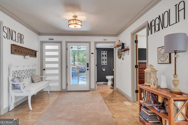 foyer entrance featuring light tile patterned flooring and ornamental molding