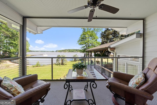 balcony with ceiling fan and a water view