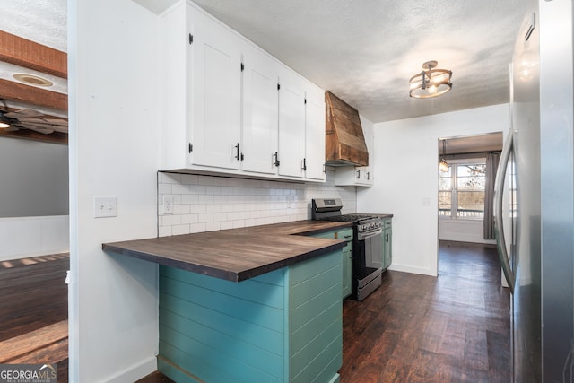 kitchen with dark wood finished floors, decorative backsplash, appliances with stainless steel finishes, white cabinetry, and butcher block countertops