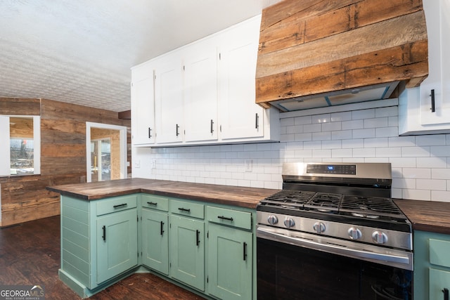 kitchen featuring dark wood-style floors, custom range hood, wooden counters, backsplash, and stainless steel gas range oven