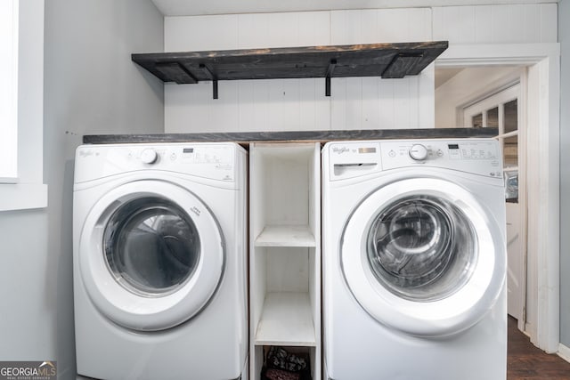 clothes washing area with laundry area, washing machine and dryer, and dark wood-style flooring