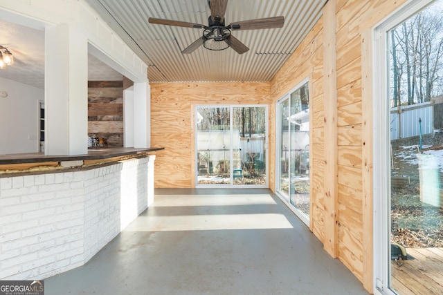 unfurnished sunroom with ceiling fan