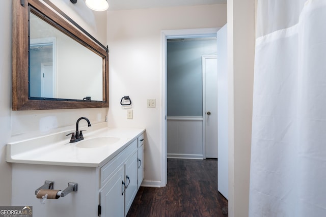 bathroom with wood finished floors, vanity, and baseboards