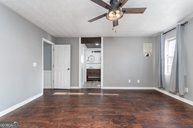 unfurnished living room featuring a ceiling fan, baseboards, and wood finished floors