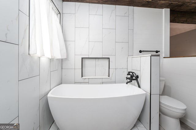 full bathroom featuring toilet, a soaking tub, and tile walls