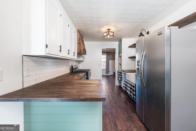 kitchen with stainless steel appliances, tasteful backsplash, dark wood-type flooring, white cabinetry, and a textured ceiling