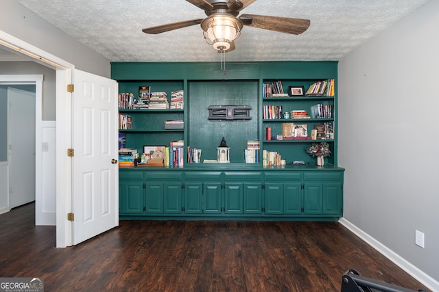 interior space featuring a textured ceiling, wood finished floors, a ceiling fan, and baseboards