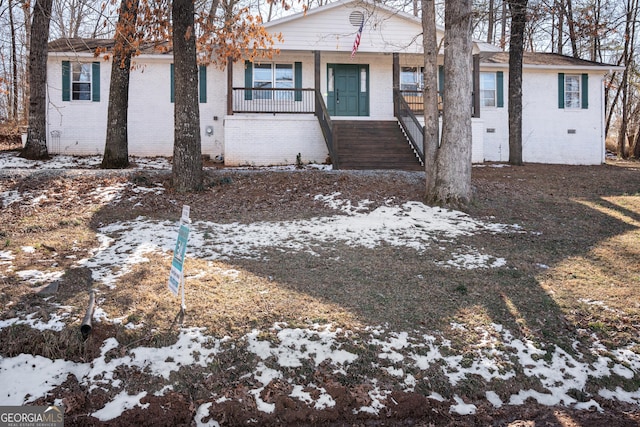 view of front of home with stairs, a porch, and brick siding