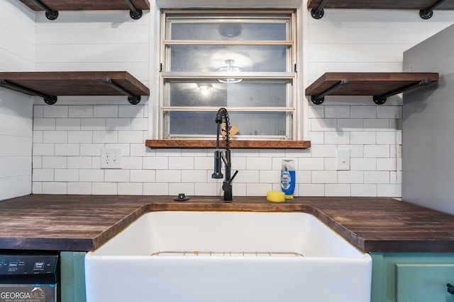 kitchen with decorative backsplash, a sink, and dishwashing machine