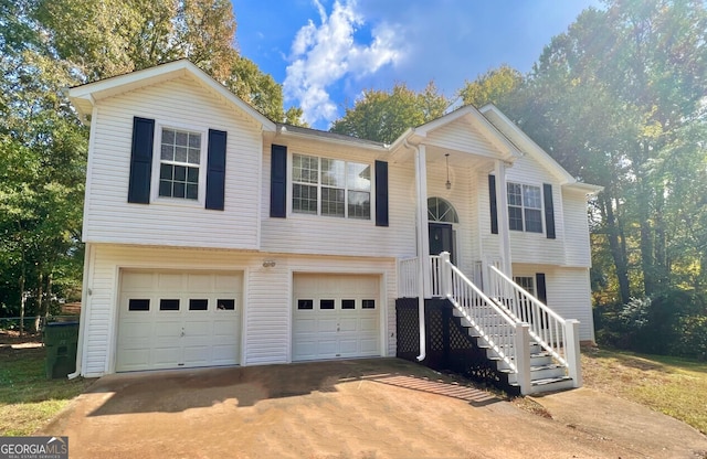 raised ranch featuring an attached garage and concrete driveway