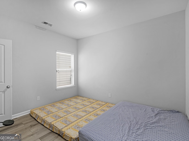 bedroom with visible vents and wood finished floors