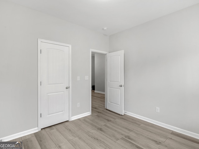 unfurnished bedroom with baseboards and wood finished floors