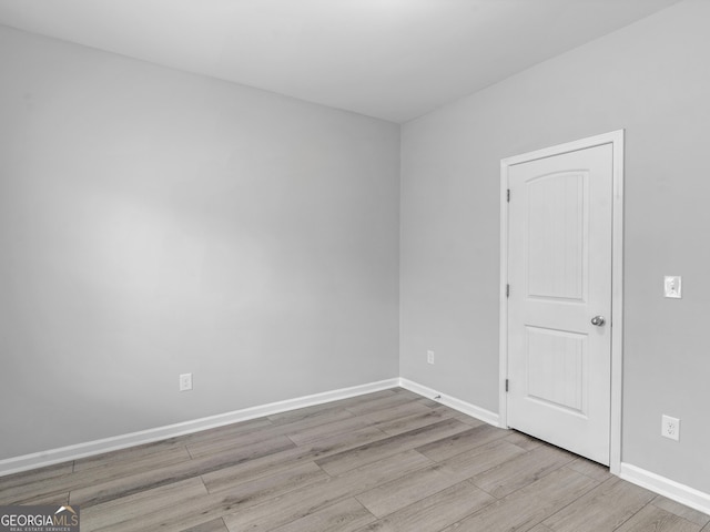 empty room with baseboards and wood finished floors