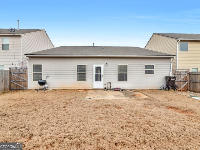 back of property featuring a lawn, a fenced backyard, and a gate