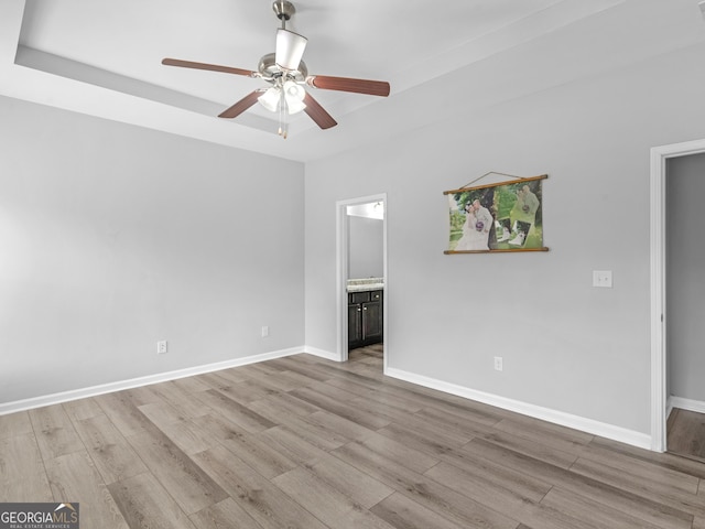 spare room with light wood-style floors, baseboards, and a ceiling fan