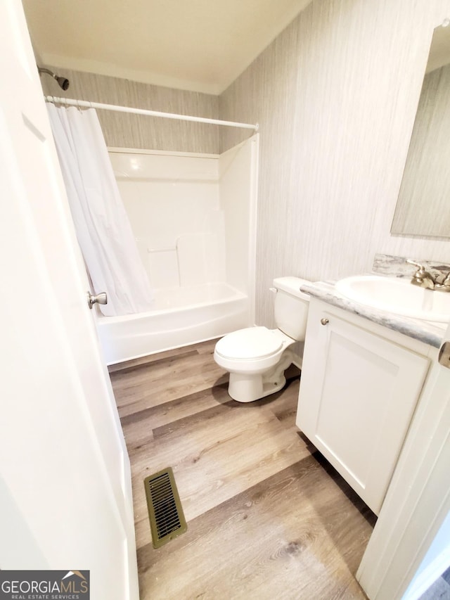 full bathroom with toilet, wood finished floors, visible vents, vanity, and shower / tub combo with curtain