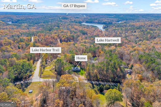 drone / aerial view featuring a water view and a wooded view