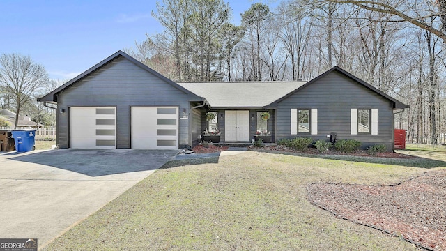 view of front of property with a garage, a shingled roof, concrete driveway, and a front yard