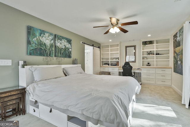 bedroom with recessed lighting, a barn door, built in study area, and light colored carpet