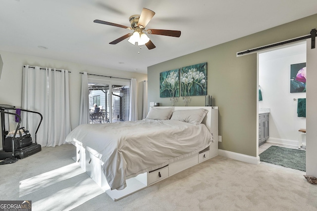 bedroom with a barn door, baseboards, connected bathroom, access to exterior, and carpet flooring