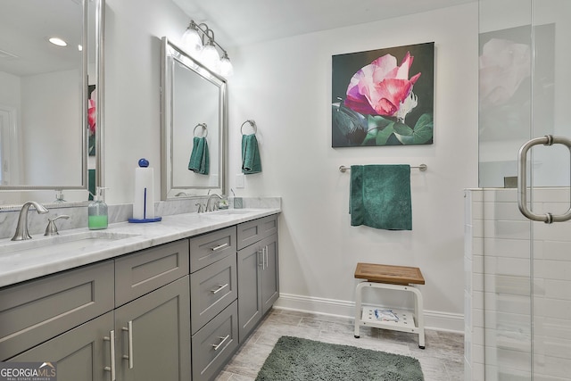 full bath featuring double vanity, a sink, visible vents, and baseboards