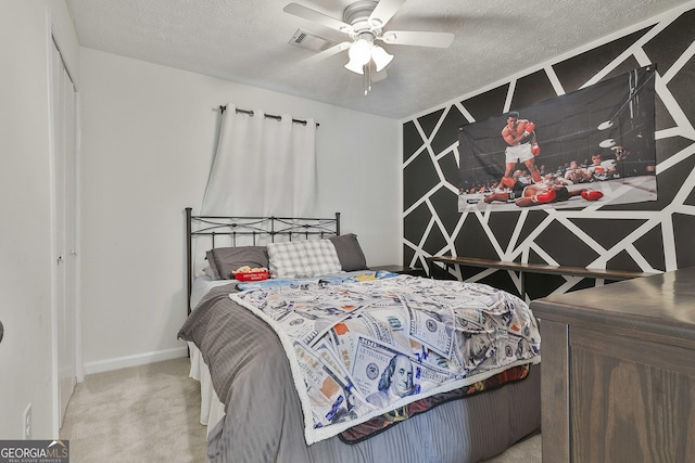 carpeted bedroom featuring a ceiling fan, visible vents, a textured ceiling, and baseboards