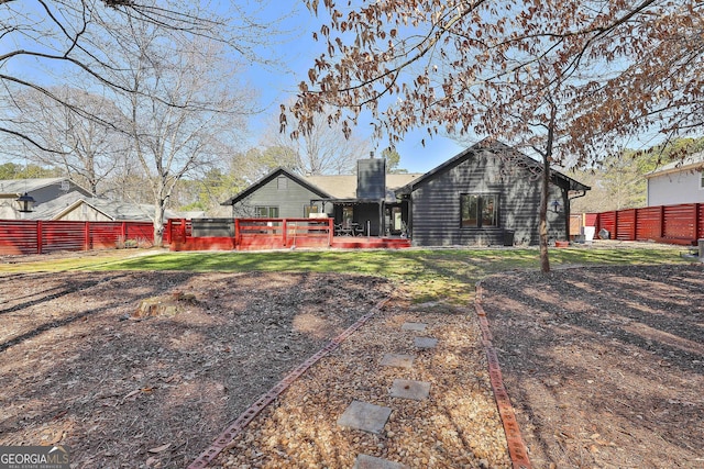 back of house with fence and a chimney