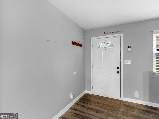 foyer entrance with dark wood-style floors and baseboards