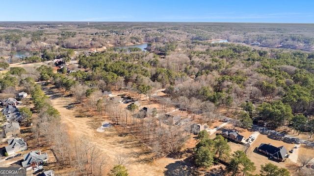 drone / aerial view featuring a forest view and a water view